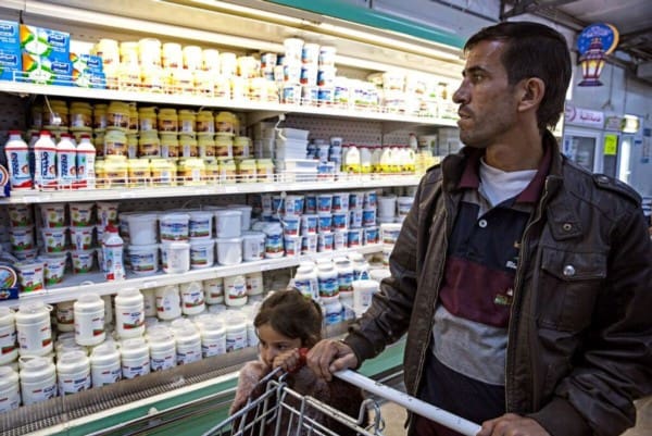 Marouf buys groceries with Noor from Zaatari’s Tazweed market purchased using WFP’s e-cards.