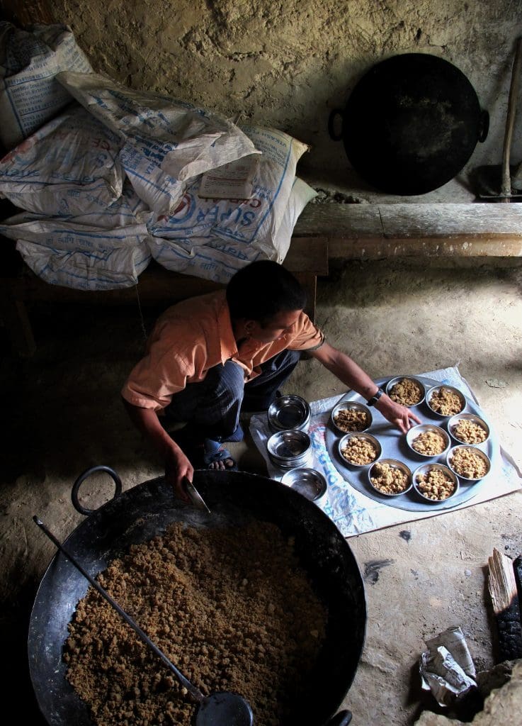 A cook prepares school meals in Nepal using WFP’s fortified grains to meet a child’s daily dietary needs