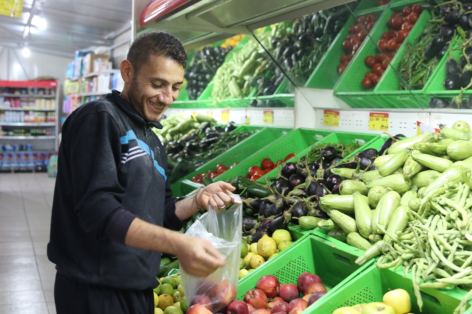 Nidal shops for vegetables in the supermarket of the Boynuyogun refugee camp in Turkey