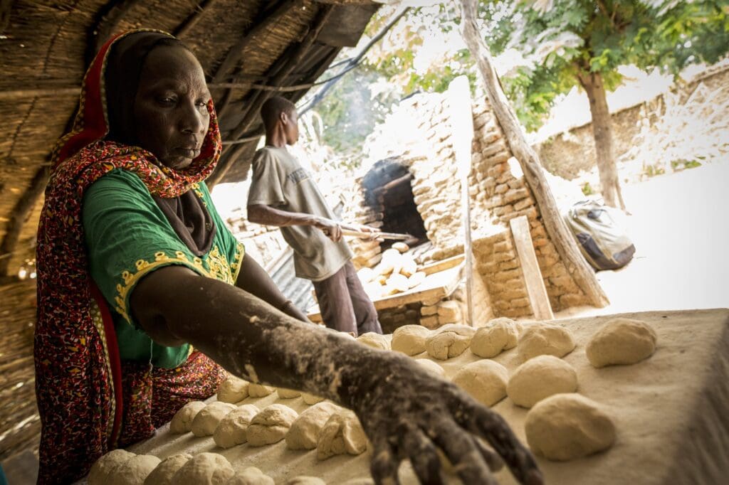 A woman places rows of dough on a table