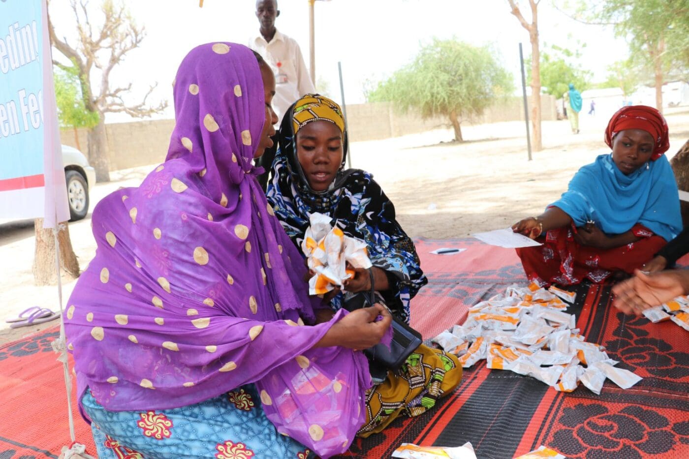 women receives packets of peanut for their children