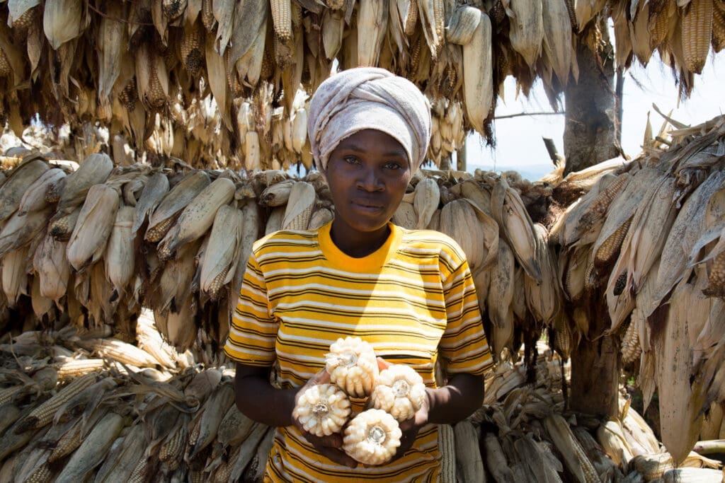 28-year-old Fideline Ayinkamiye shows the corn she’ll sell via the Farm to Market Alliance. 