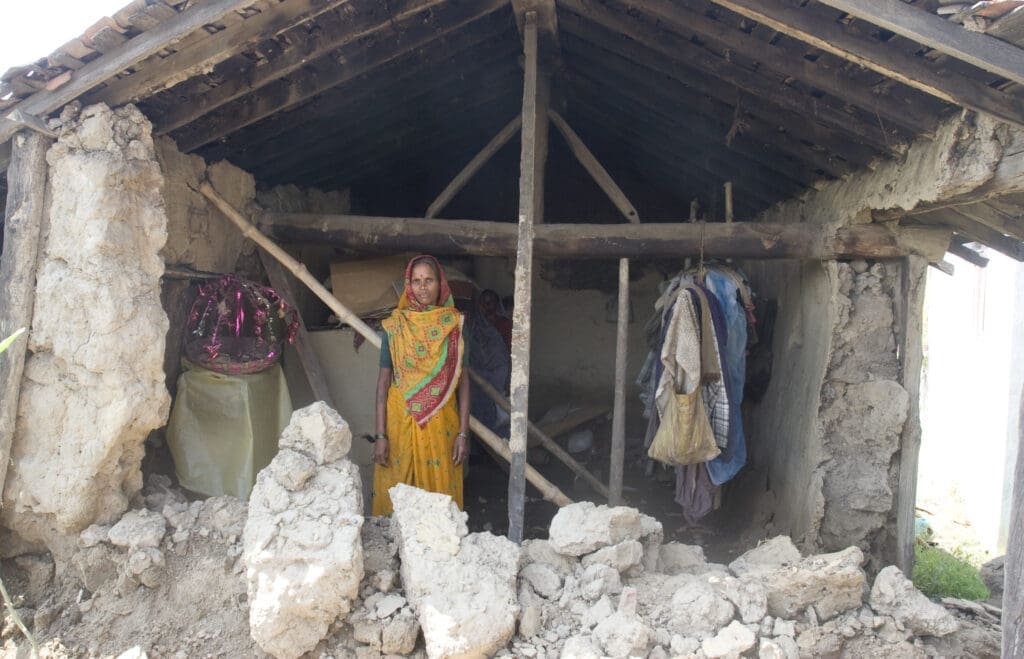 Gyanu Kori stands inside the remains of her family’s home in Nepal