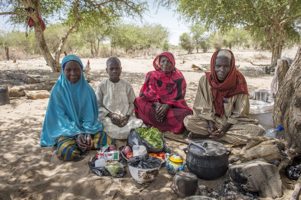 A family sits under a tree in Chad, Africa