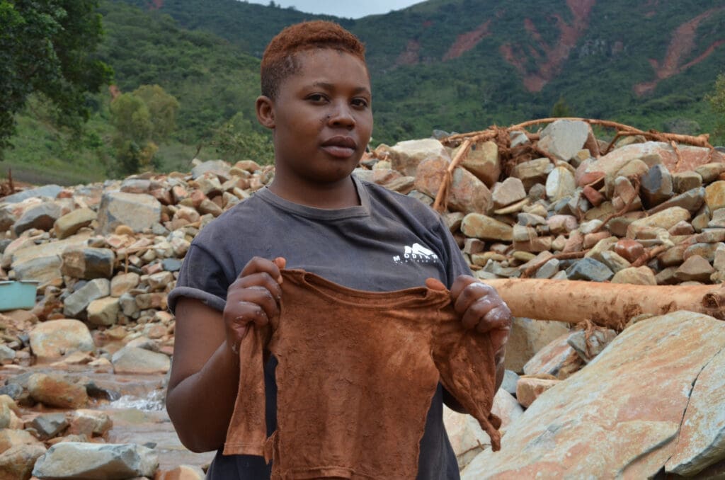 A woman holds up her deceased daughter's shirt following a landslide