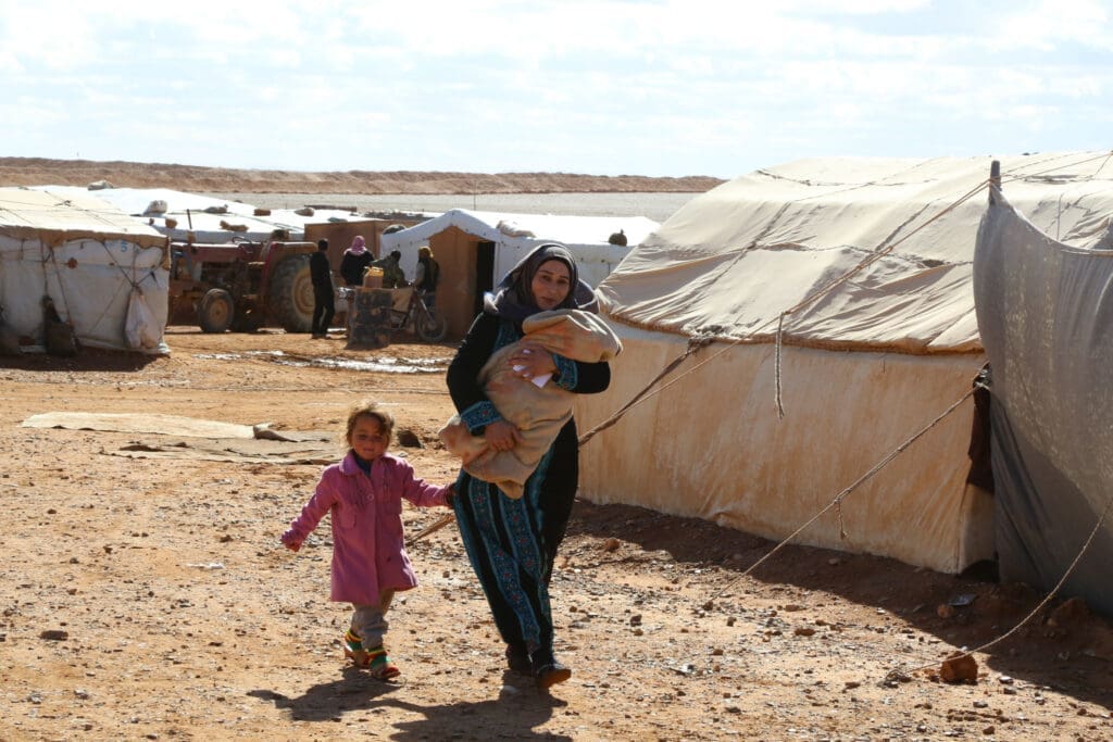 A woman and her two daughters at a refugee camp in Syria