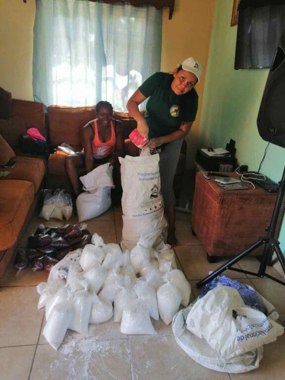 A teacher unloads a food delivery in a family living room