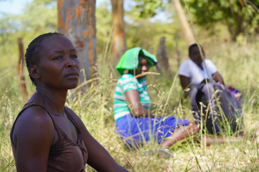 Women sit in the grass while socially distancing during Coronavirus