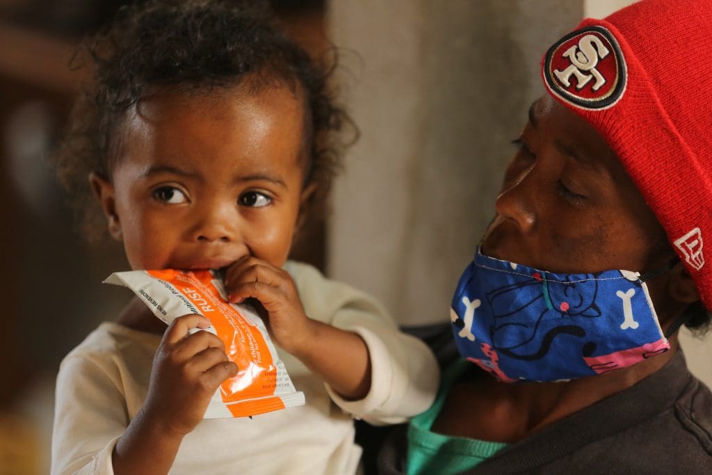 a little girl eats WFP nutrition bar