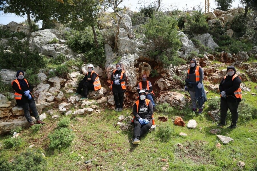group of people in orange vests in forest