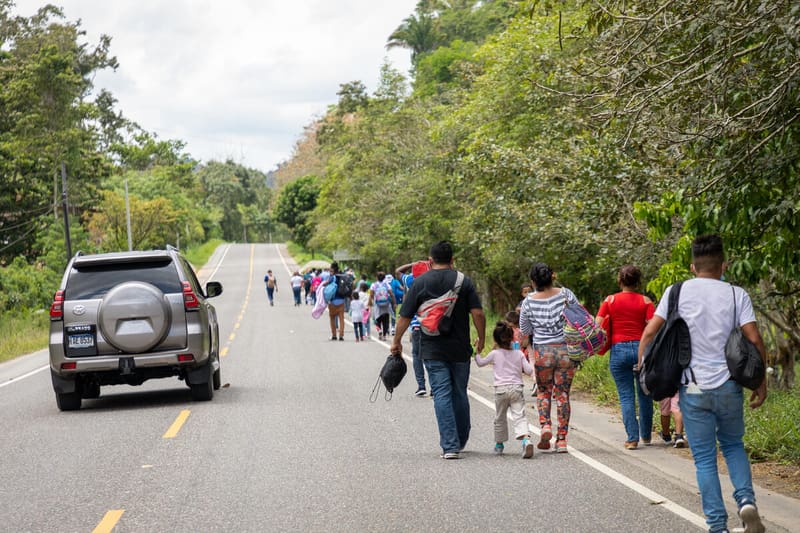 migrants walk on road