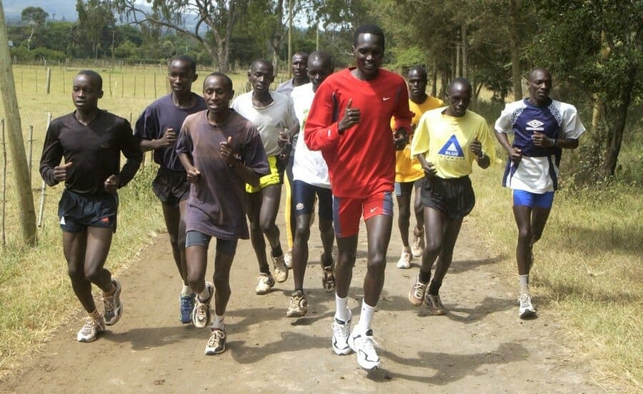 man in red shirt running with schoolchildren