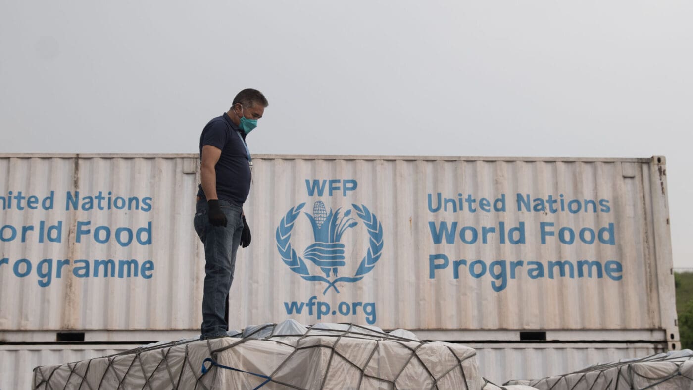 man in black shirt stands next to WFP shipment crate