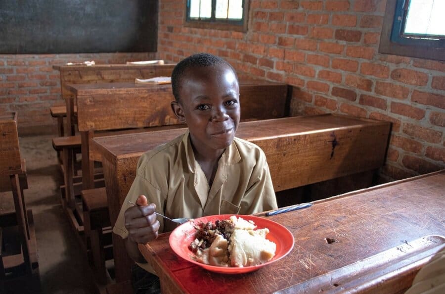 boy in brown school uniform eating lunch
