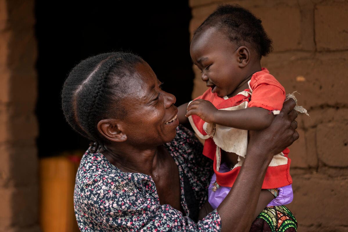 woman holding her grandson and smiling
