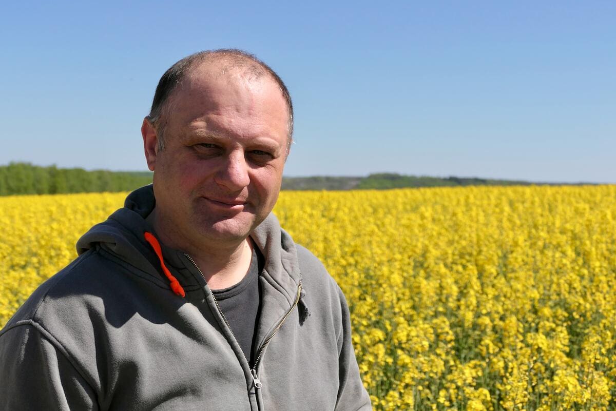 Ukrainian farmer stands in wheat field